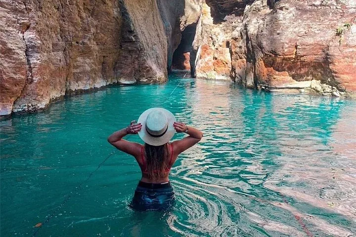 Frau mit Hut im blauen Wasser des Canyons am La Leona-Wasserfall.
